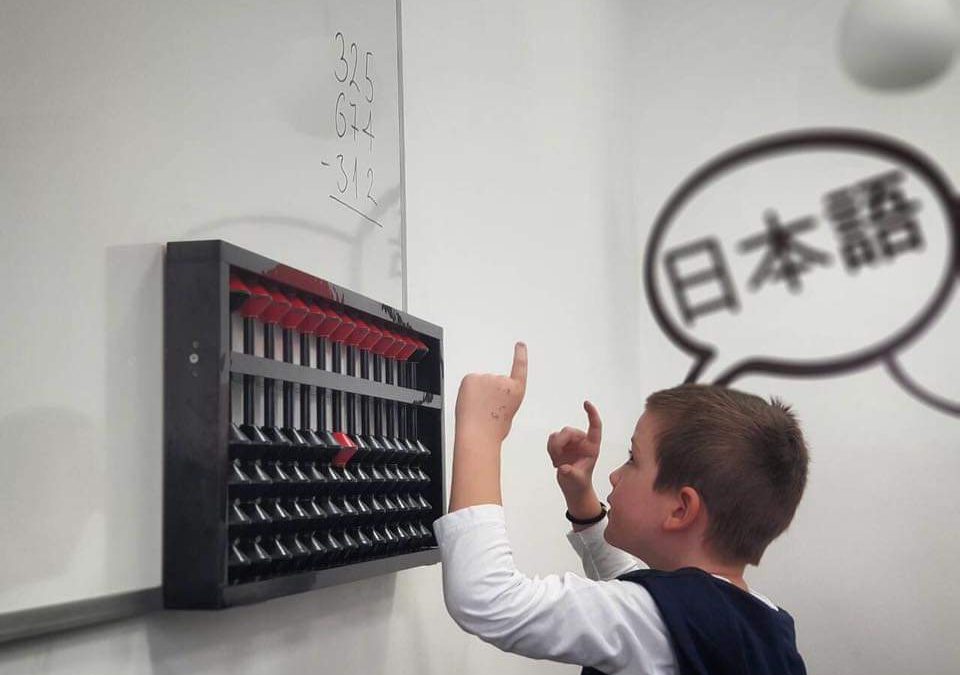 Kind leert rekenen met telraam (abacus) in klaslokaal.